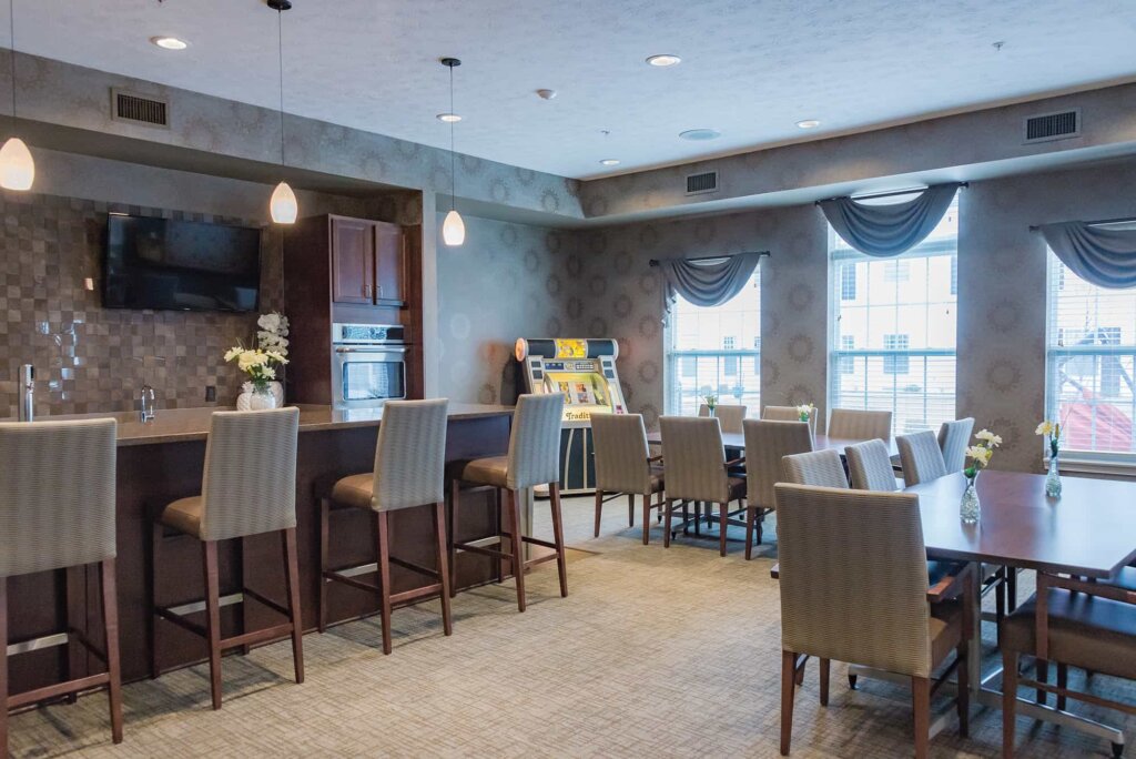Bistro at Traditions at Brookside featuring a built-in kitchenette, High-top bar stools, a mounted TV, and a jukebox.