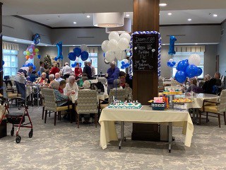Many tables are shown with decorations and blue balloons